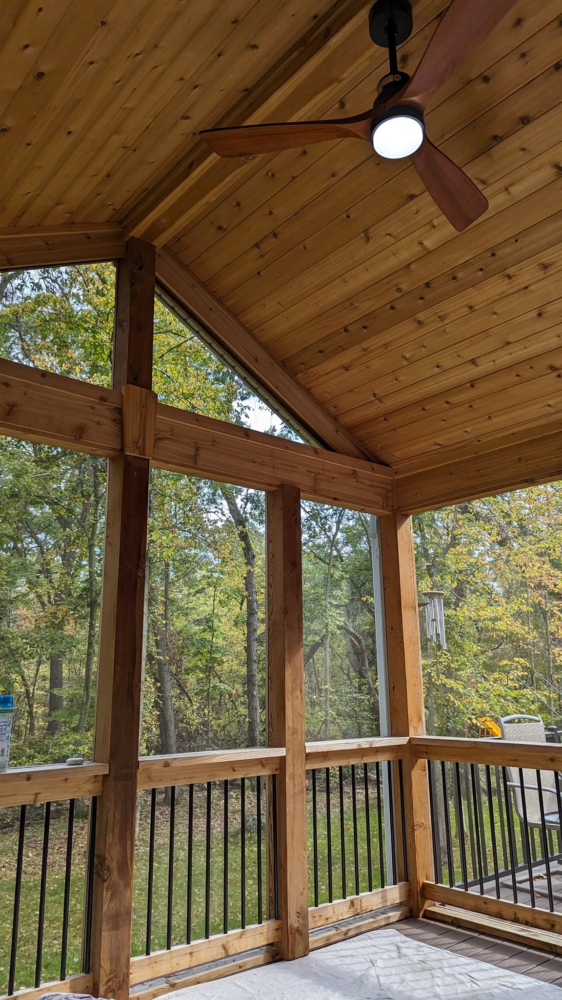 A screened porch finished in warm stained cedar