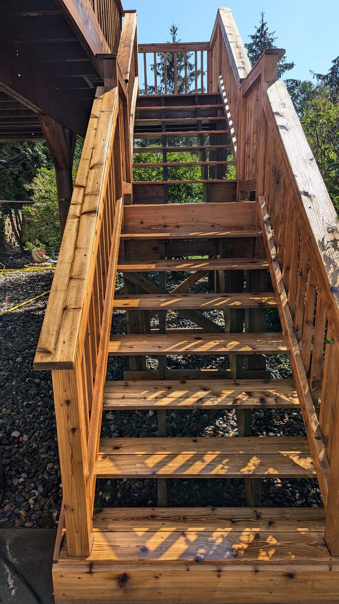 Multi-level deck stairs repaired and stained with black railings