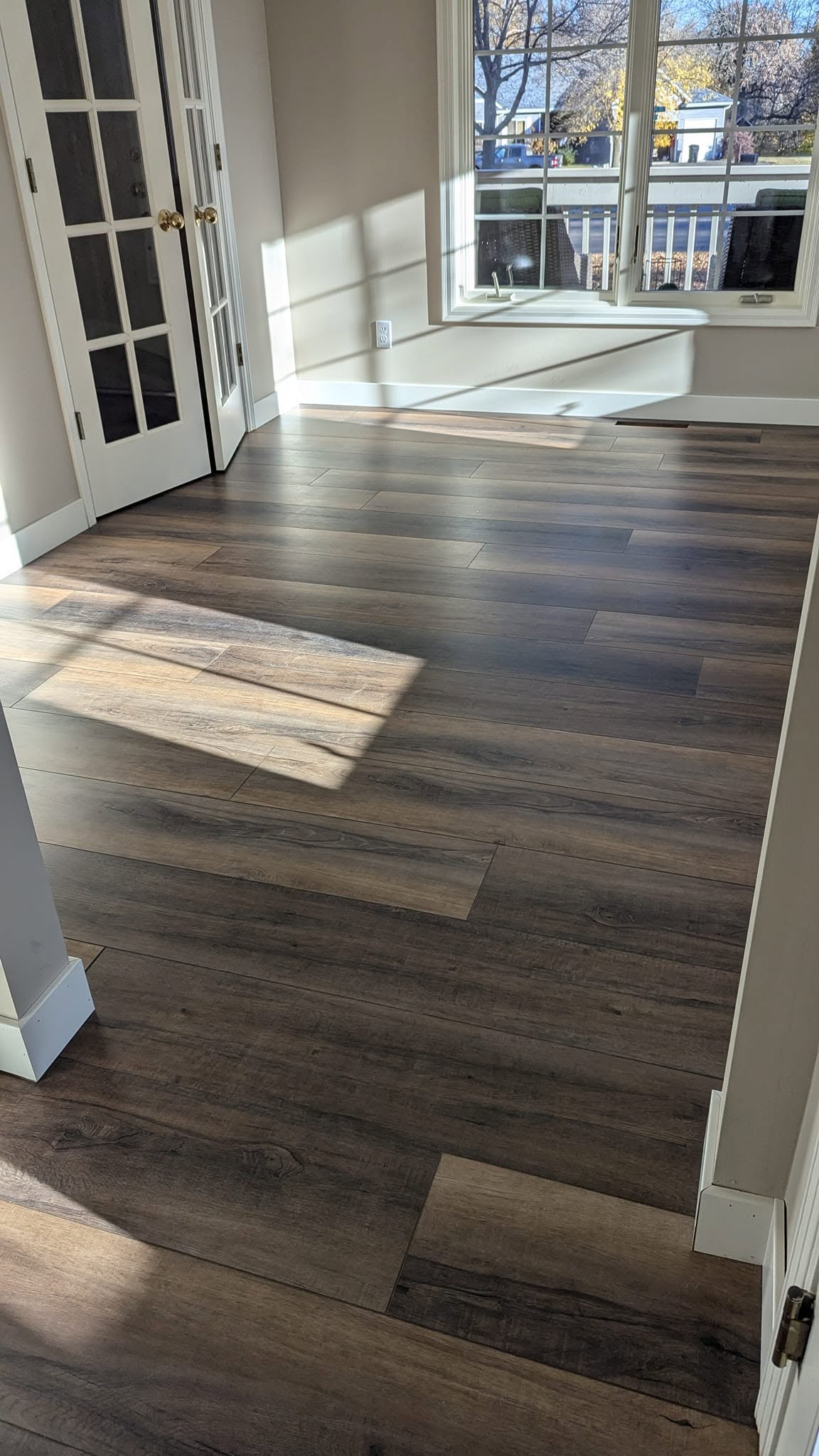 Resanded and refinished hardwood floors catching the light in a front entry