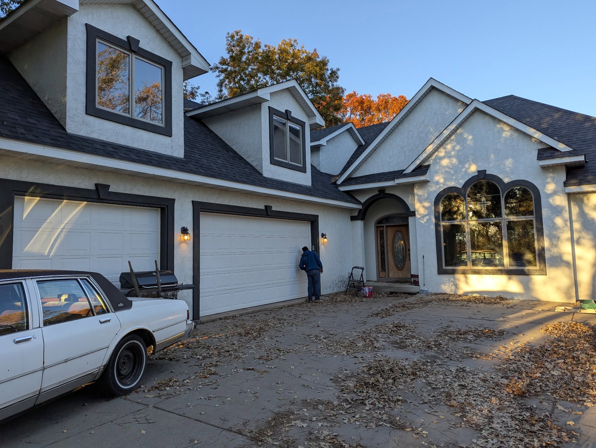 A full exterior repaint on a two-story home, finished in warm evening light